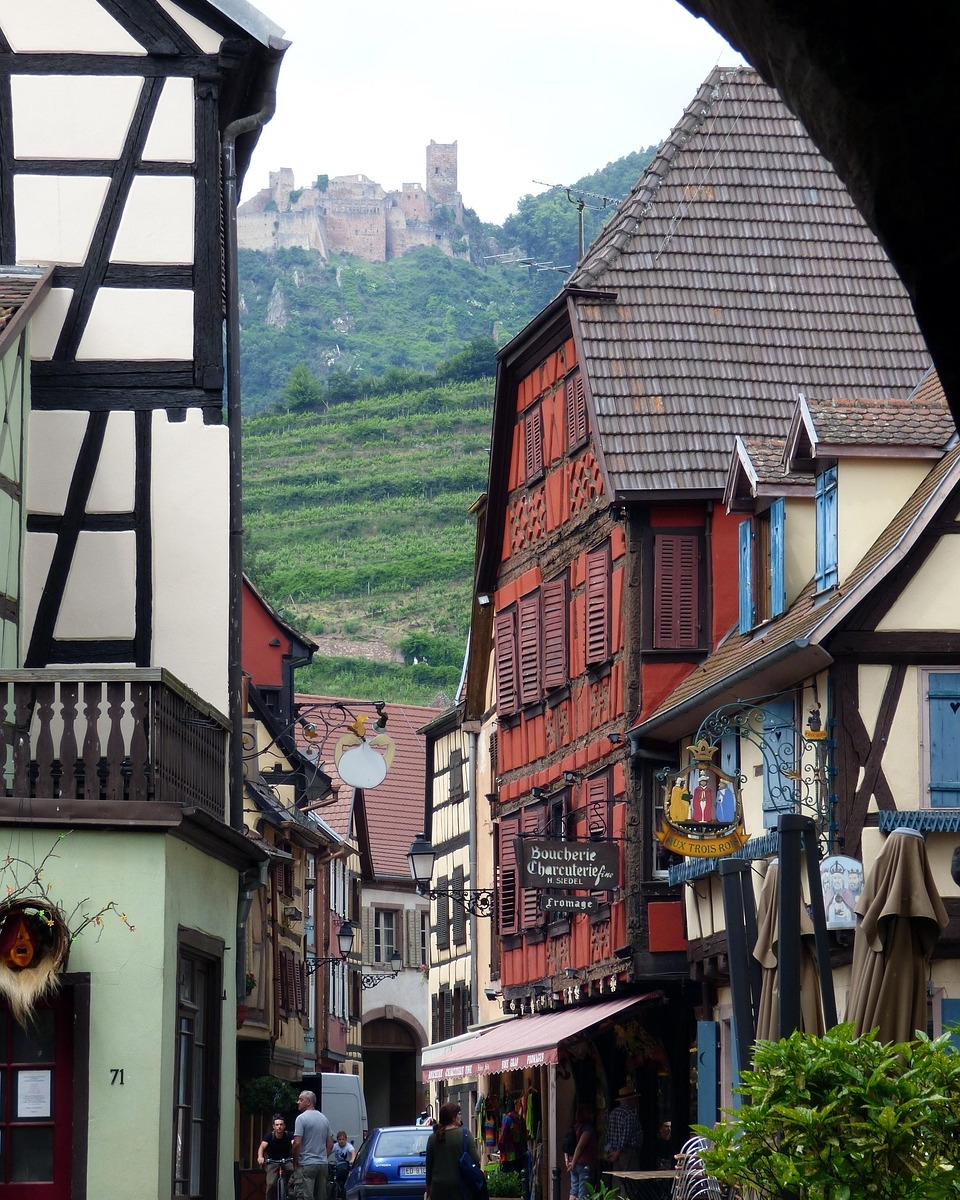 Grande rue de Ribeauvillé et ses maisons à colombages, avec les châteaux sur les hauteurs, Route des Vins d’Alsace. Adaptez-le à ce que montre vraiment votre photo.